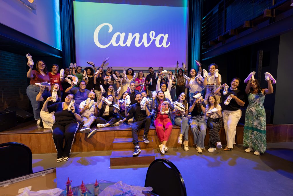Large group celebrating with personalized shoes at a Canva event indoors